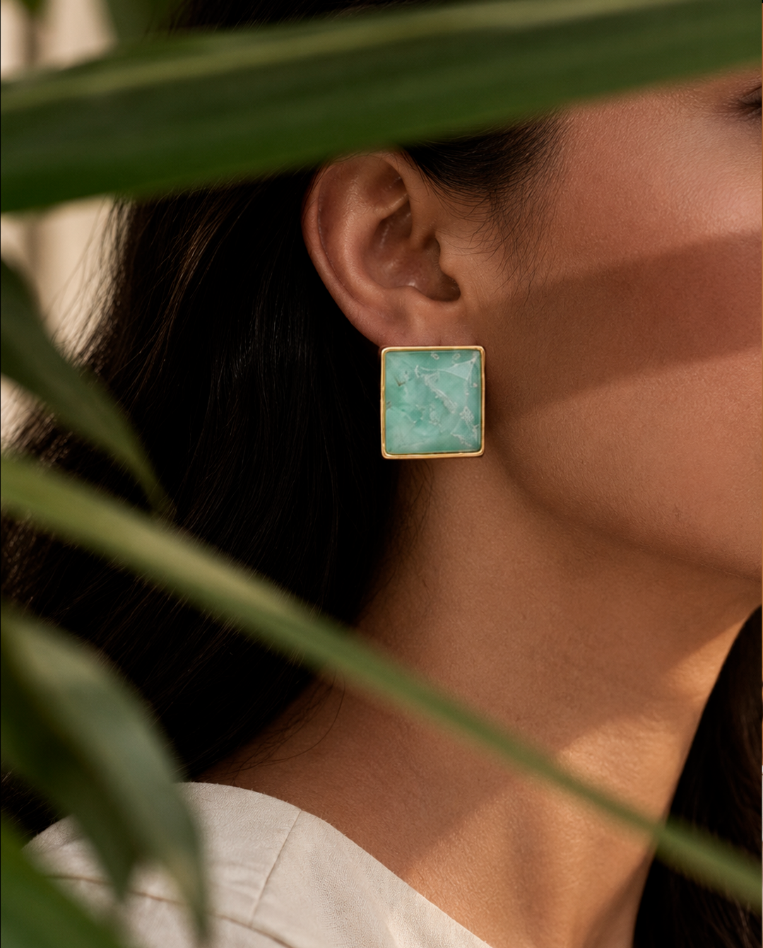 Model wearing aquamarine stud earrings with 18k gold-plated bezel, Selva Line by Azulique.