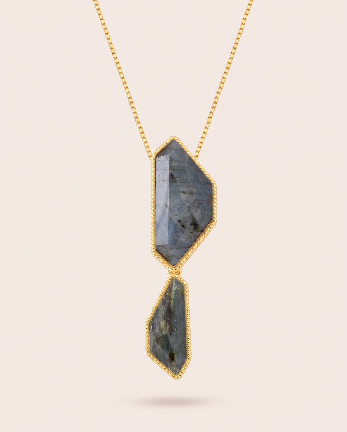 Vertical front view of the Nocturne necklace featuring two faceted, geometric blue labradorite stones in rope-detailed gold-plated bezels suspended from a fine gold box chain.