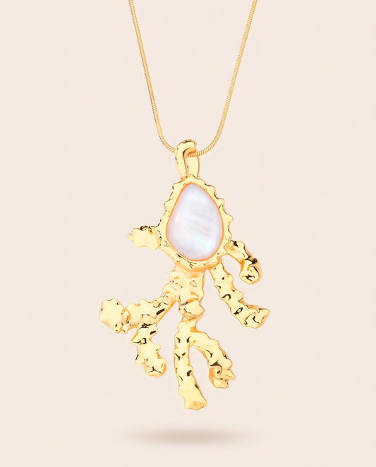 Long gold-plated Coralia coral branch pendant necklace with pear-shaped mother of pearl worn over a square neckline top