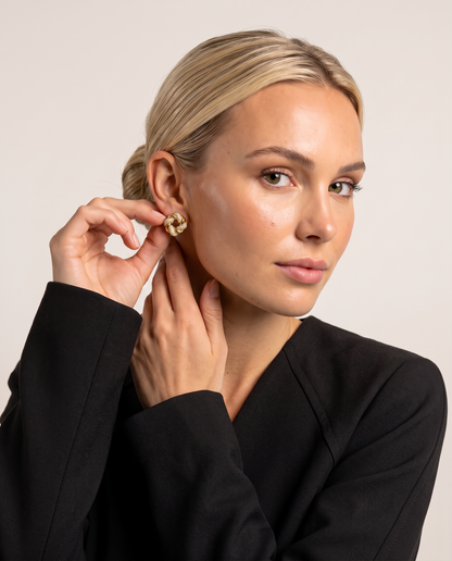Cut crystal earrings with a woven gold-plated finish, worn by a model.