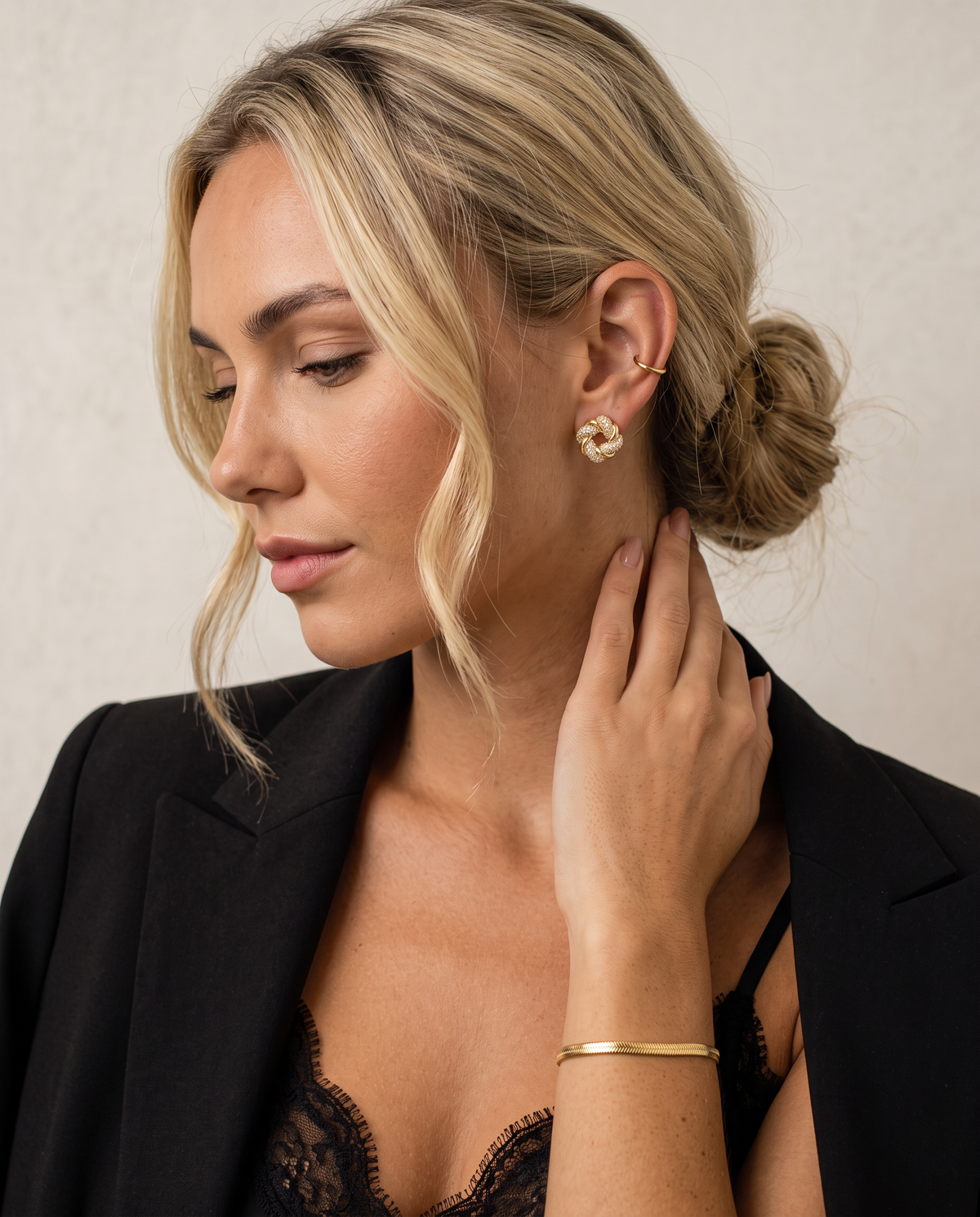 Cut crystal earrings with a woven gold-plated finish, worn by a model.