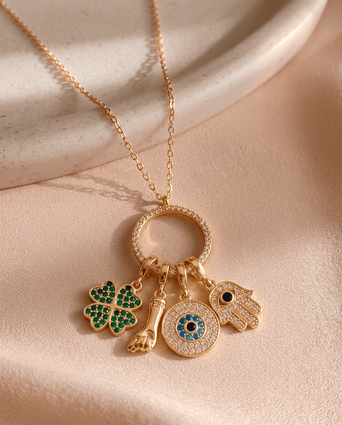 Gold plated Sorte lucky charm necklace with cubic zirconia figa, four leaf clover, evil eye and hamsa charms.