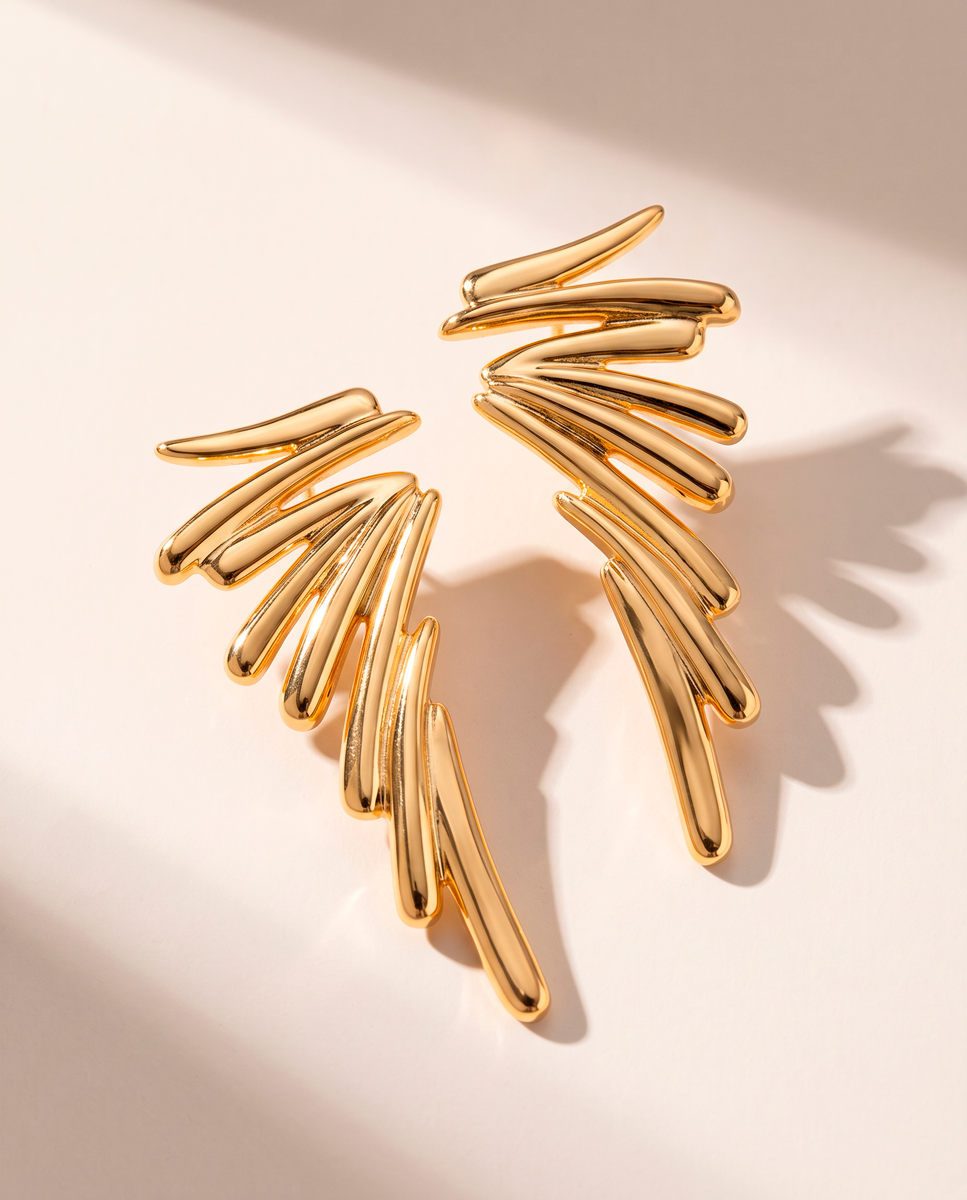 Gold wing statement earrings with sculptural graduated ribs and 18k gold-plated finish, Selva Line by Azulique.