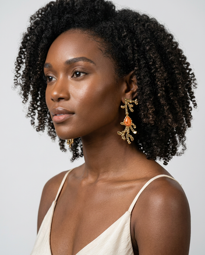 Model wearing orange calcite sculptural earrings with 18k gold-plated finish, Selva Line by Azulique.