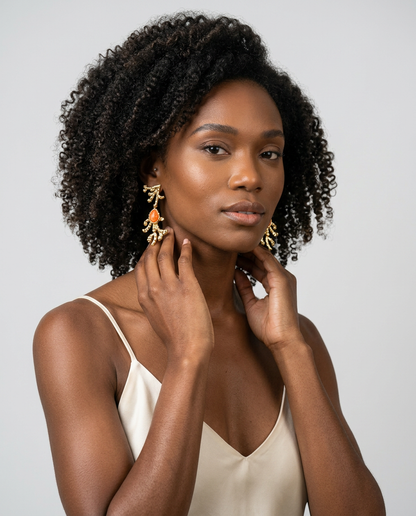 Model wearing orange calcite sculptural earrings with 18k gold-plated finish, Selva Line by Azulique.