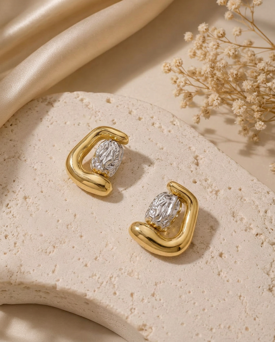 Obsydian two-tone statement earrings with a rounded gold finish and textured silver-tone center.