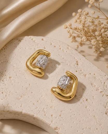 Obsydian two-tone statement earrings with a rounded gold finish and textured silver-tone center.